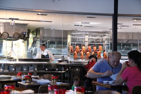 wide view of restaurant interior with windows looking into the kitchen