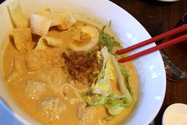 A bowl of noodles in a creamy broth