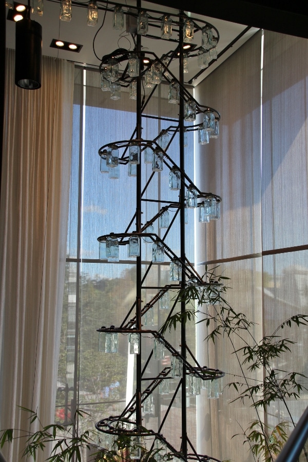 a tall display of glass bottles near a window