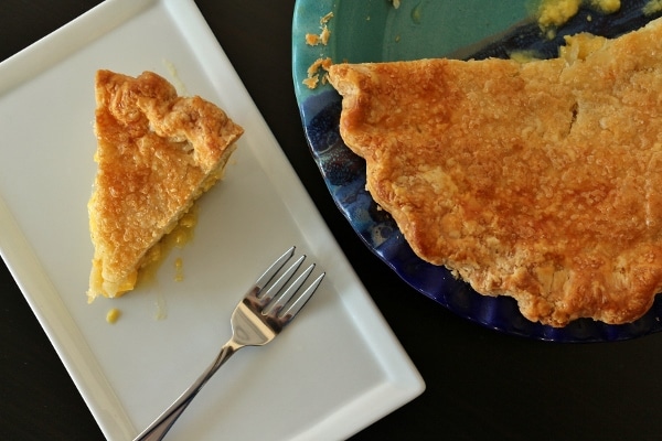 overhead view of a slice of pie next to a blue pie dish