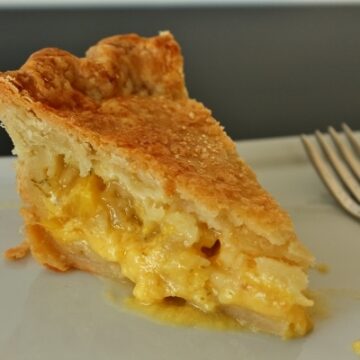 side view of a slice of pineapple pie on a white plate