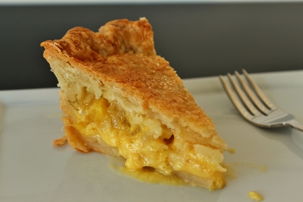 closeup of a slice of pineapple pie on a white plate