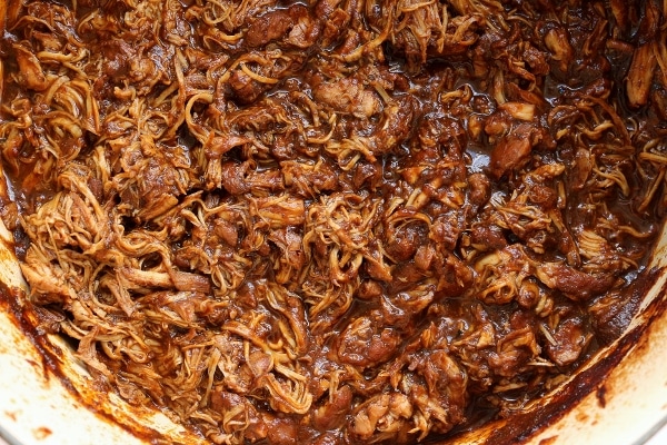 A pot of shredded braised chicken in a dark brown spicy sauce