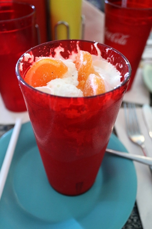 a creamy drink in a red cup topped with orange candies