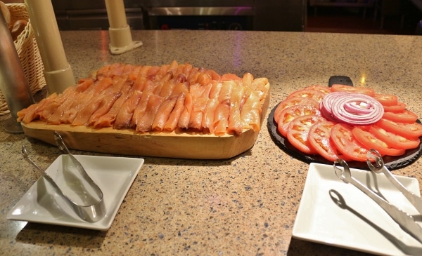 smoked salmon, sliced tomatoes and red onions on a buffet