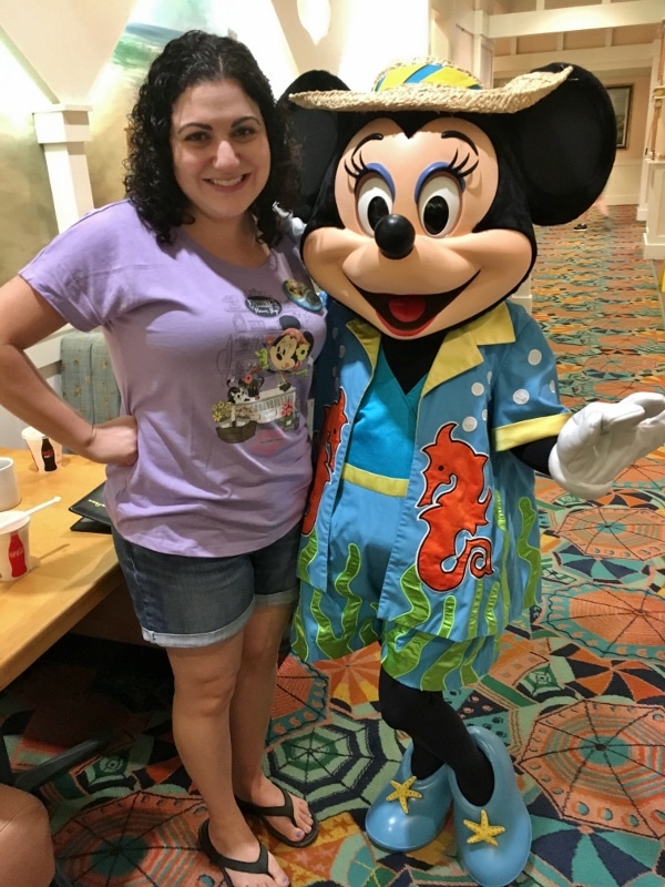 A woman posting with Minnie Mouse