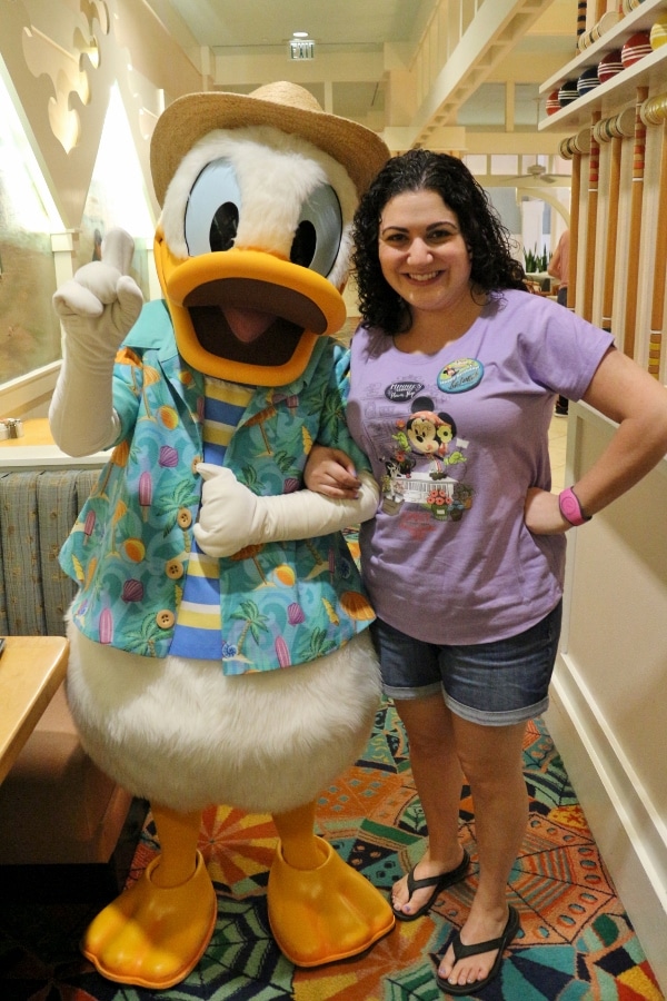 a woman posing with Donald Duck