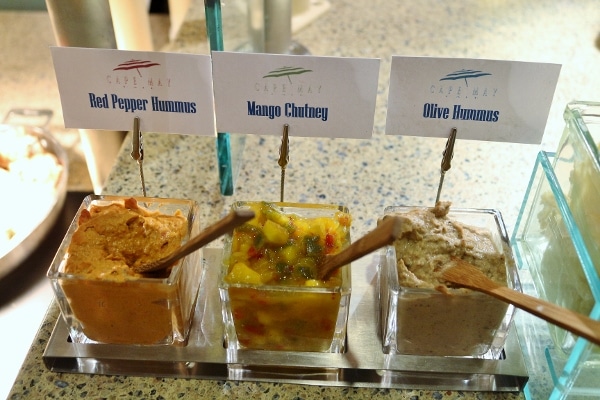 a few different sauces and spreads on a buffet