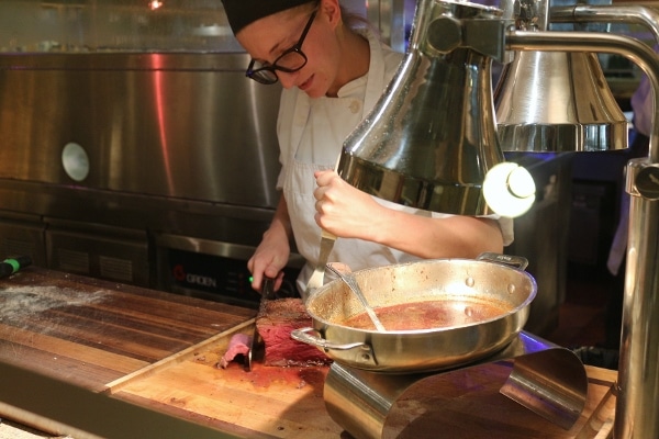 A person slicing roast beef