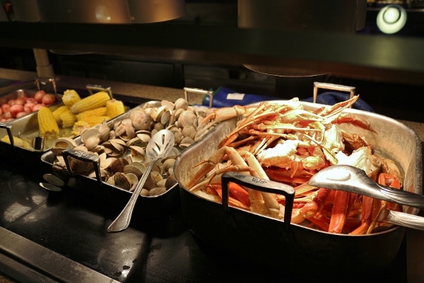 crab legs, steamed clams, and corn on the cob on a buffet