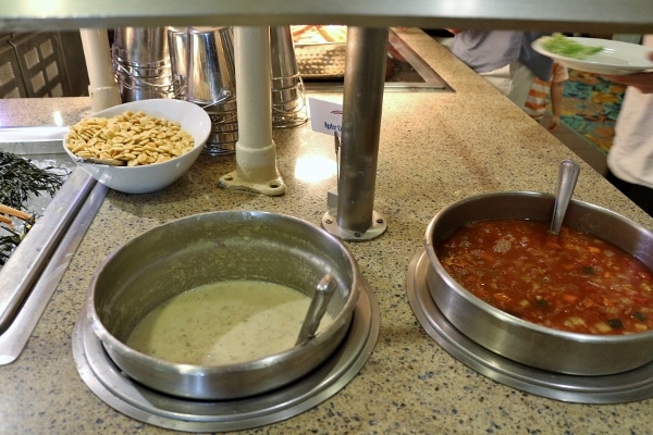 a couple pots of soup on a buffet