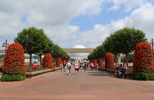 A group of people walking down a walkway in Epcot