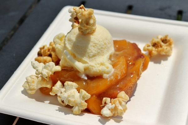 a plate of food with peaches, ice cream, and popcorn