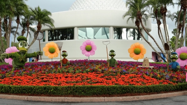 a topiary display of Donald Duck and his nephews with garden tools