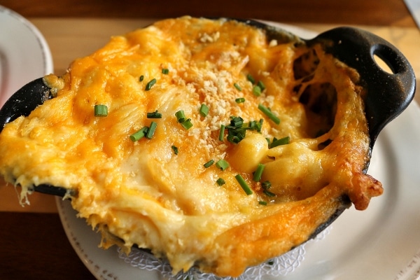 A close up of crock of baked macaroni and cheese