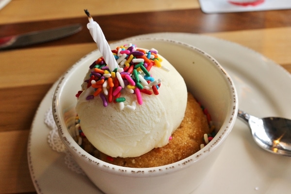 a donut topped with a scoop of ice cream and sprinkles