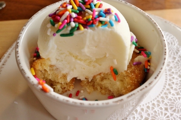 a half-eaten donut topped with ice cream and sprinkles