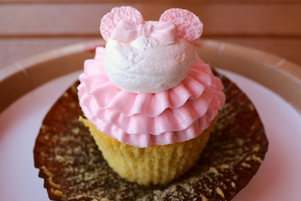 A close up of a cupcake with pink frosting