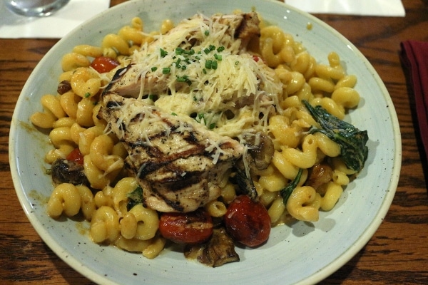 a plate of pasta topped with chicken and cheese