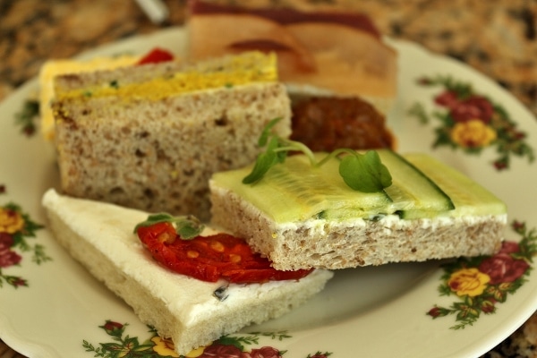 a variety of tea sandwiches on a floral plate