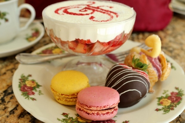 macarons and a chocolate covered strawberry on a dish