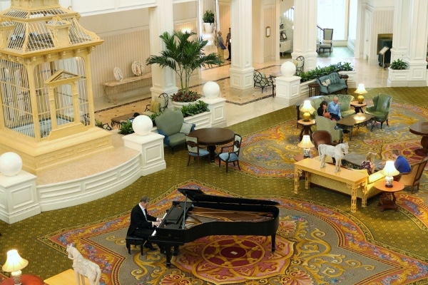 a man playing the piano in a hotel lobby