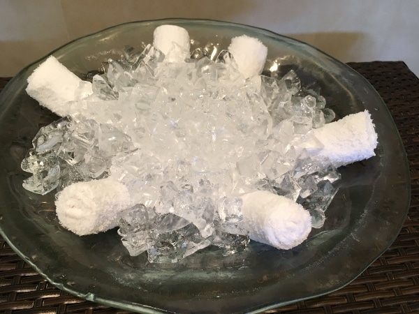 a bowl of ice with rolled up towels