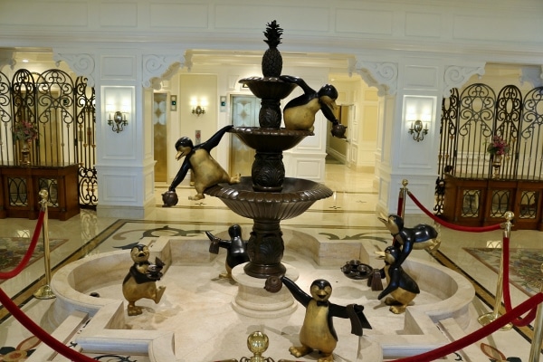 an indoor fountain with statues of penguins