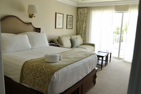 A bedroom with a bed and love seat in a hotel room