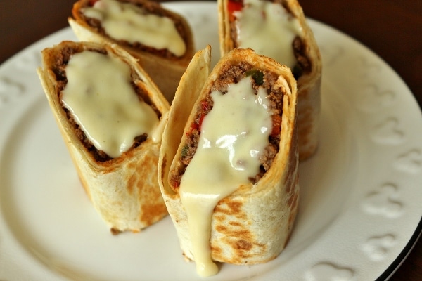 close up of Mexican hot pockets with cheese sauce