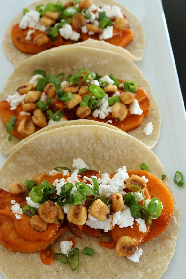 A close up of 3 sweet potato tacos on a white plate