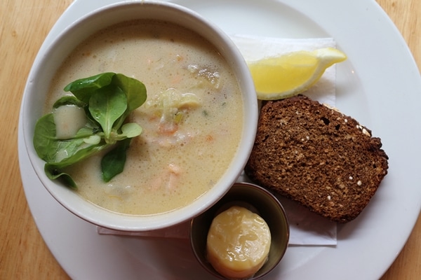 overhead view of a bowl of salmon chowder with brown bread