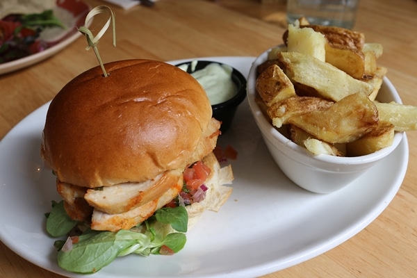 a chicken sandwich on a plate with fries