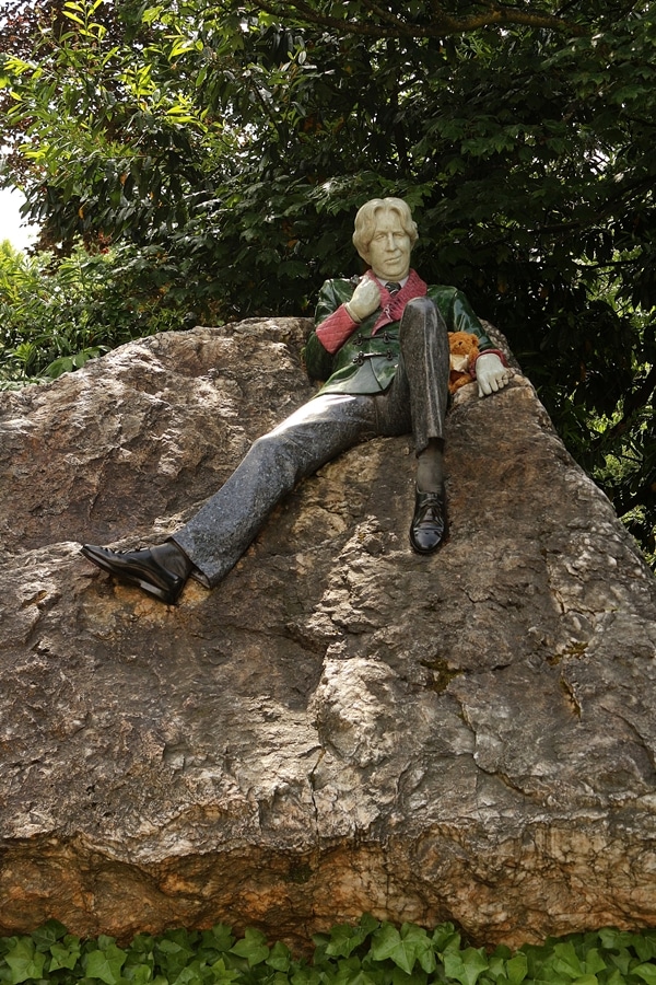 A statue of a man sitting on a rock