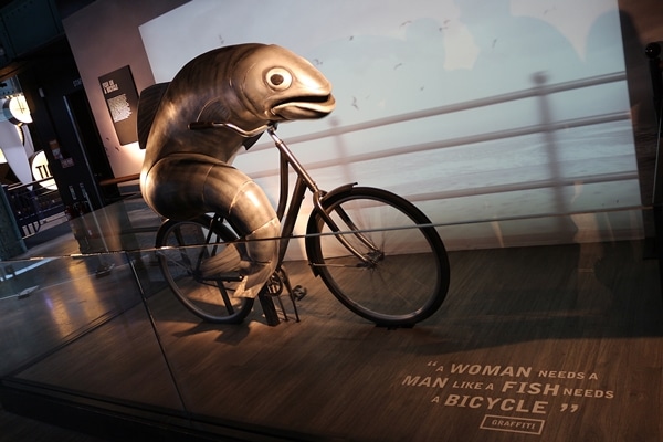 a statue of a fish on a bicycle