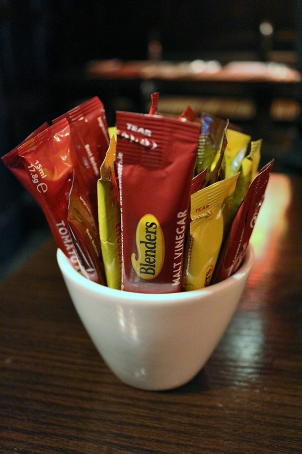 A cup filled with packets of condiments