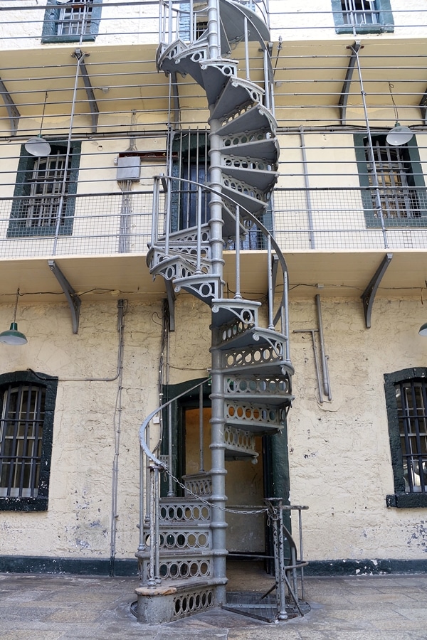 a metal spiral staircase in an old prison