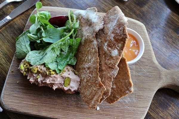 crispy flatbread served with a meat pate and greens