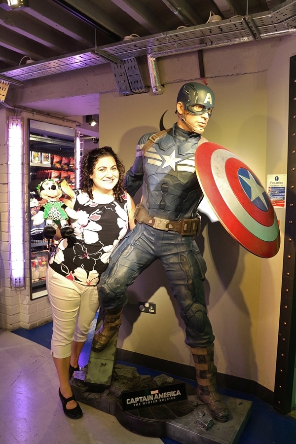 A woman posing with a statue of Captain America