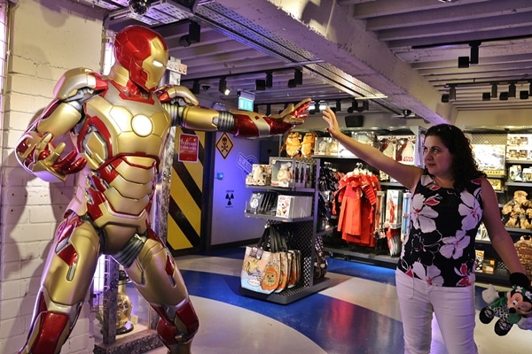 A woman posing with a statue of Iron Man