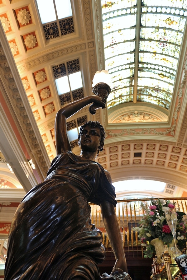 a statue inside a restaurant with tall ceilings