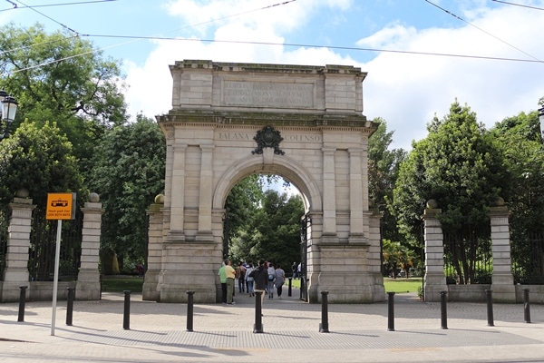 a stone arch in front of a park