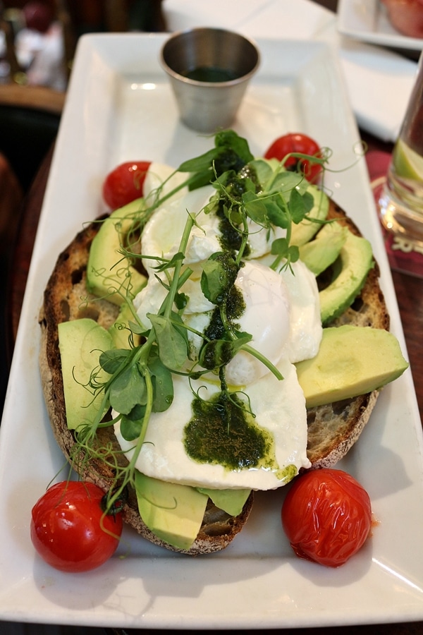 A plate of avocado toast with pesto and eggs