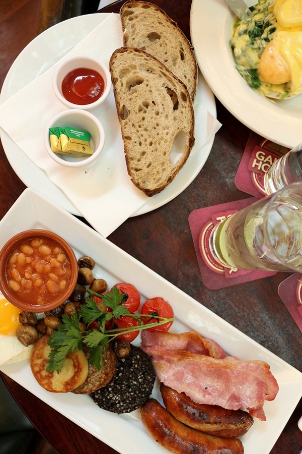 overhead view of plates of breakfast food on a wood table