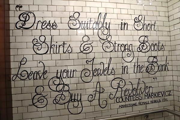 a quote written out on white subway tiles