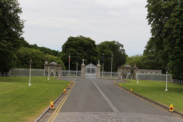 a long driveway with a gate at the end