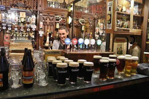 a bar lined with glasses of Guinness and other beer