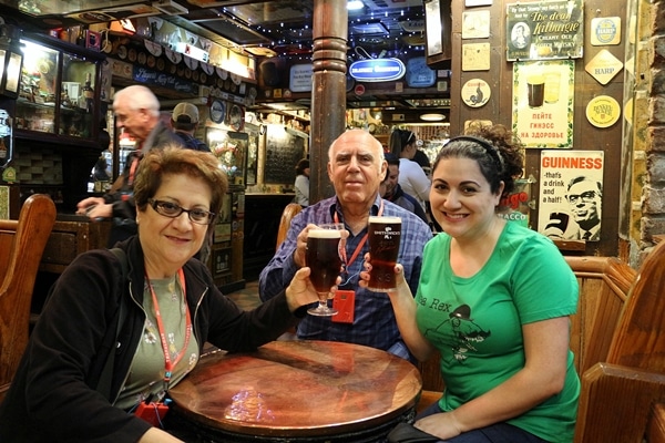 A group of people sitting at a table in a pub holding drinks