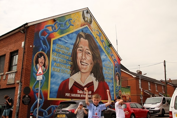 children playing in front of a building with a painted mural