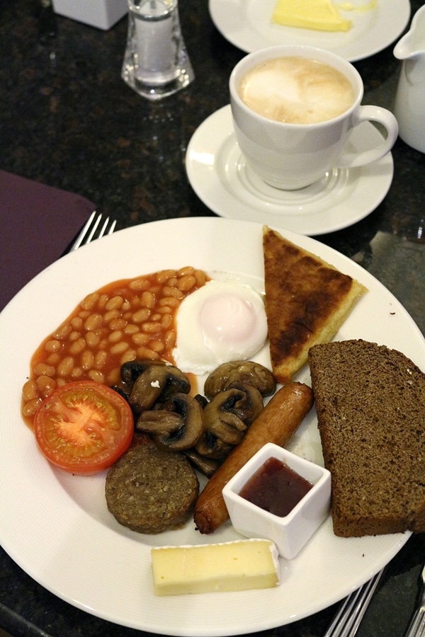 a full Irish breakfast on a plate and a cup of coffee